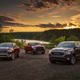 Three Ram 1500 diesels parked on dirt at sunset.